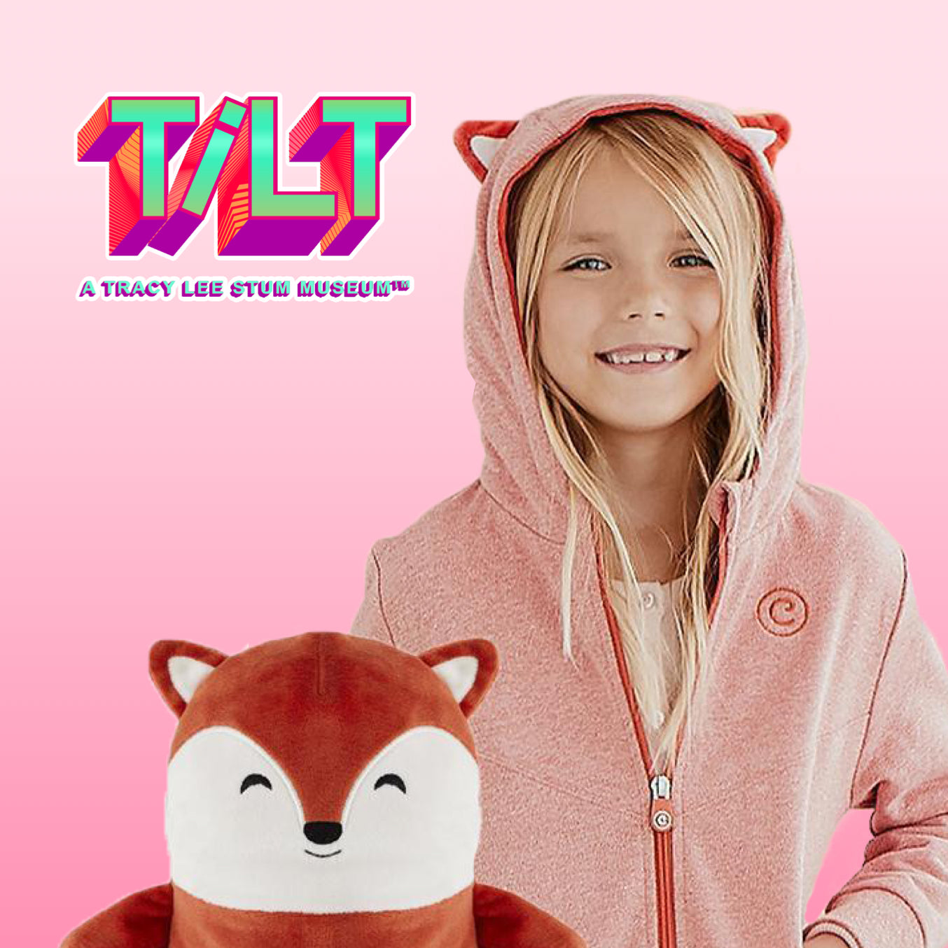 girl wearing flynn the fox zip up hoodie with flynn the fox plush toy